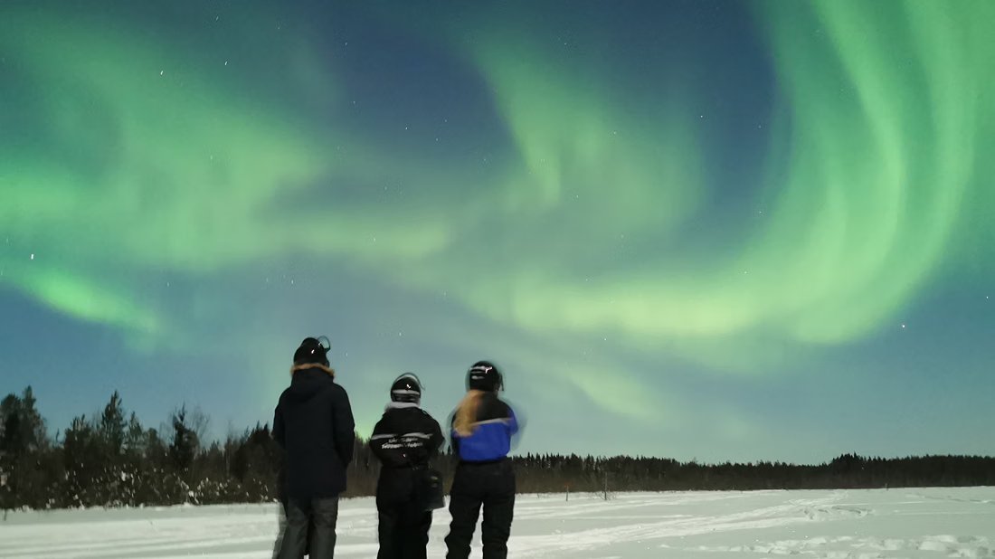 Gäste beobachten Nordlichter auf einem zugefrorenen See