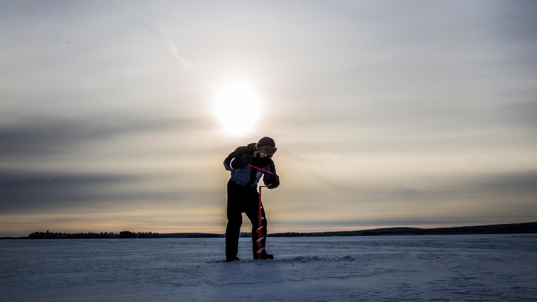 Silhouette eines Eisanglers im Sonnenlicht