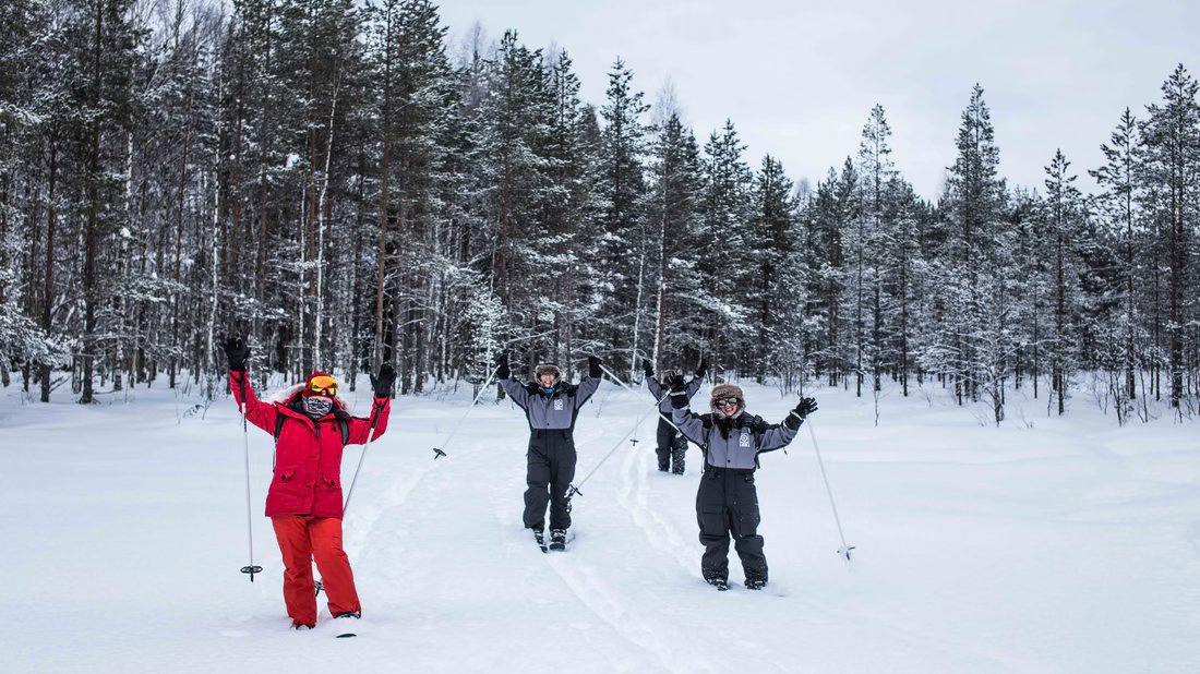Skieurs manifestant leur joie dans une forêt enneigée